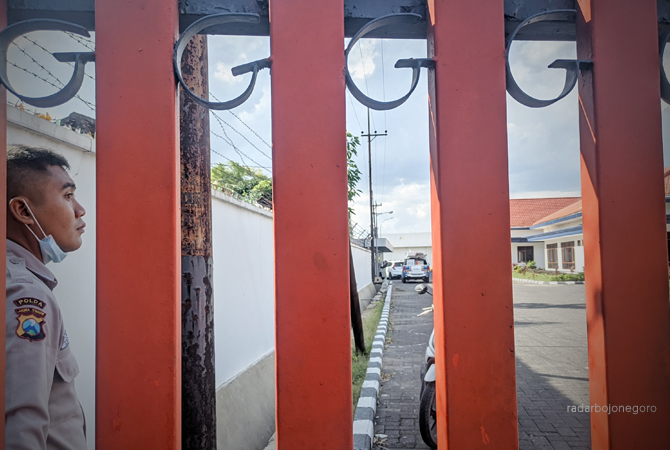 DIJAGA: Petugas keamaan menjaga pagar bangunan milik Gudang Garam di Desa Kedungbondo kemarin. (DHANI WAHYU ALFIANSYAH/RDR.BJN)