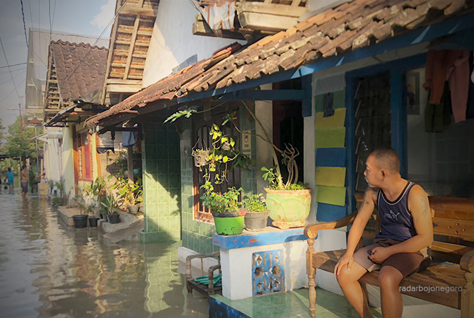 AIR MELUAP: Seorang warga Ledok Wetan melihat air memasuki depan rumah. (RAHUL OSCARRA DUTA/RDR.BLORA)