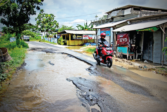 BAKAL DICOR: Kondisi ruas jalan Glagah yang rusak. Jalan ini menjadi jalur alternatif menuju Gresik saat jalan nasional mengalami kemacetan. (ANJAR DWI PRADIPTA/RDR.LMG)