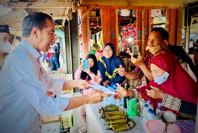 SAPA PEDAGANG: Presiden Jokowi didampingi Bupati Blora Arief Rohman menyerahkan bantuan kepada Mbah Rati yang berjualan lontong sayur di Pasar Mendenrejo kemarin. (LUKMAN HAKIM/RDR.BLORA)