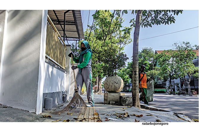 SAPU SAMPAH: Petugas kebersihan menyapu sampah di trotoar jalanan perkotaan. Selama arus mudik dan balik, ada peningkatan sampah. (DHANI ALFIANSYAH/RDR.BJN)
