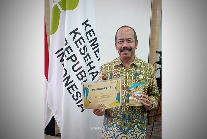 PRESTASI: Kepala Dinkes Blora Edy Widayat menunjukkan piagam dan trofi dari Kemenkes RI. (ISTIMEWA FOR RDR.BLORA)
