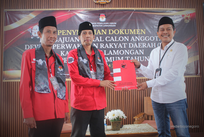 BERSEMANGAT: Ketua DPC PDI Perjuangan Lamongan, Husen didampingi Sekretaris DPC PDI Perjuangan Lamongan, Reso Supranoto menyerahkan berkas kepada Ketua Komisioner KPU Kabupaten Lamongan, Mahrus Ali. (AHMAD ASIP/RDR.LMG)