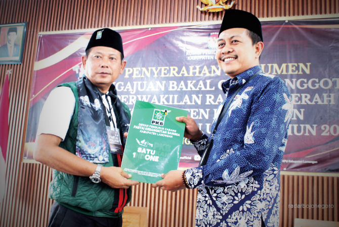 BULATKAN TEKAD: Ketua DPC PKB Lamongan, H. Abdul Ghofur menyerahkan berkas pendaftaran kepada Ketua Komisioner KPU Kabupaten Lamongan, Mahrus Ali. (AHMAD ASIP/RDR.LMG)