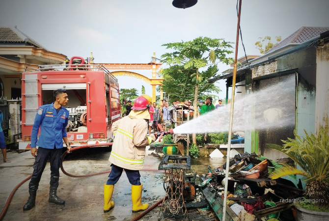 MAKAN KORBAN JIWA: Petugas melakukan pembasahan di rumah Jaya, warga Desa Tejoasri, Kecamatan Laren kemarin siang (16/5). (ISTIMEWA FOR RDR.LMG)