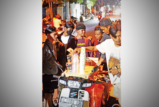 NGOPI DAN BEGADANG: Anak-anak muda memesan kopi di Jalan Hayam Wuruk. Kawasan berderet bangunan lama ini ketika malam makin ramai. (WAHYU DHANI ALFIANSYAH/RDR.BJN)