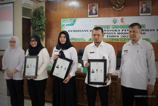 MEMBANGUN DESA: Bupati Bojonegoro Anna Mu’awanah dan Kepala Dinas PMD Machmuddin menyerahkan secara simbolis kepada tiga kades dengan status Desa Mandiri. (ISTIMEWA FOR RDR.BJN)