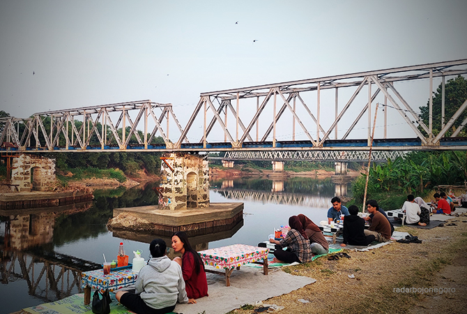 JUJUGAN AKHIR PEKAN: Anak-anak muda nongkrong dan kulineran di bawah Jembatan Bojonegoro-Cepu. Sesekali selfi dengan panorama bengawan dan jembatan. (LUKMAN HAKIM/RDR.BLORA)