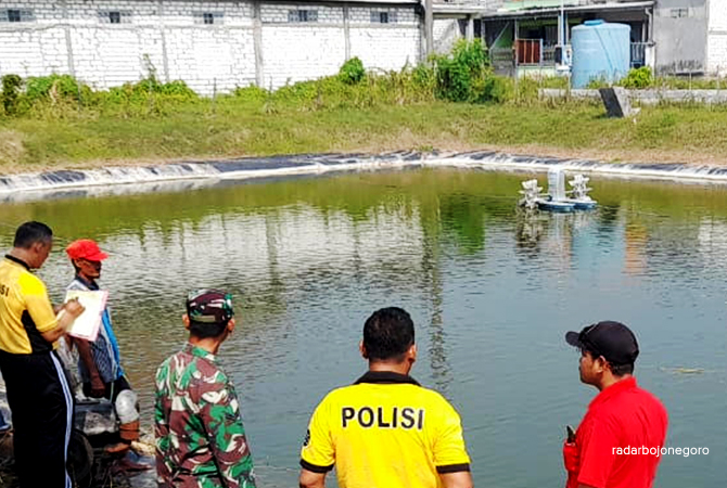 LAKUKAN PENGECEKAN: Petugas kepolisian mendatangi kolam penampungan air di Desa Dukuh Tunggal, Kecamatan Glagah, setelah bocah SD tewas tenggelam di sana. (ISTIMEWA FOR RDR.LMG)