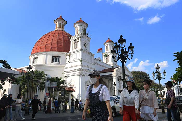 Sejumlah wisatawan terlihat asyik mengabadikan momen ketika berlibur ke kawasan Kota Lama Semarang.