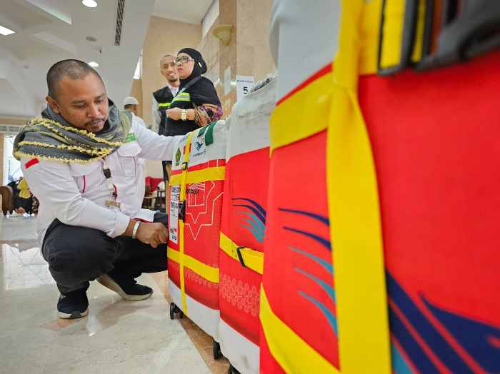 TIMBANG KOPER : Petugas dari maskapai penerbangan mulai melakukan penimbangan koper jemaah haji.