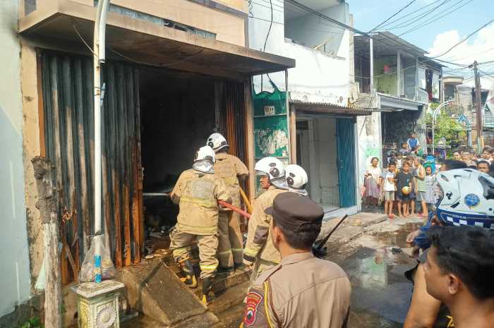 Petugas berupaya memadamkan sumber api di rumah Supangat, Jalan Jagalan Selatan.