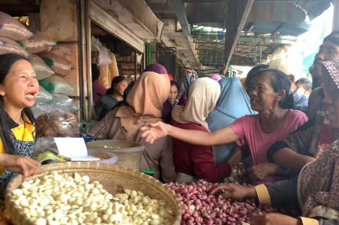 Wardini salah satu pedagang bawang di Pasar Blauran, Salatiga yang dagangannya menjadi rebutan ibu-ibu pasar, Jumat (14/7).
