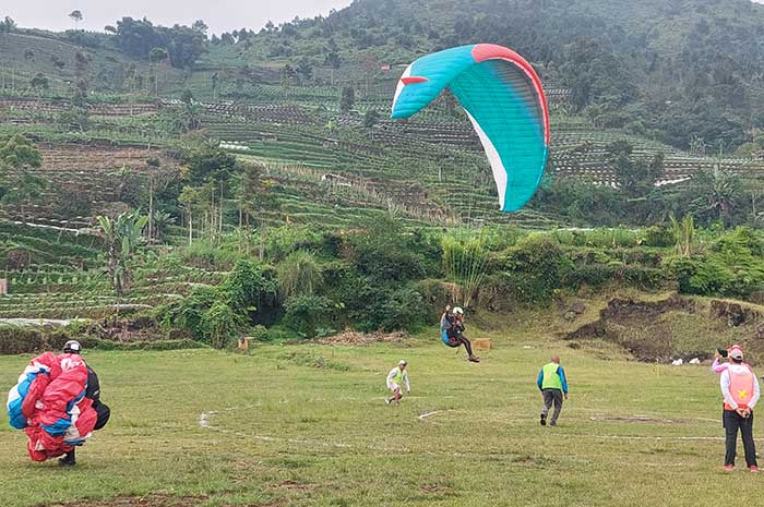Salah satu atlet paralayang saat mendarat di Bukit Kekep, Desa Lengkong, Kecamatan Garung, Kabupaten Wonosobo, Sabtu (15/7).