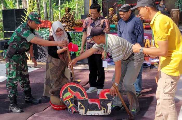 Lurah Mijen, Dyah Budi Yuniarti bersama Camat Mijen melakukan penjamasan alat pertanian dalam Festival Muharram, kemarin.