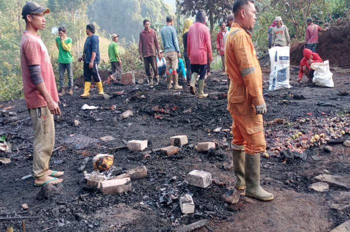 Warga bergotong royong membersihkan sisa-sisa kebakaran tadi malam.