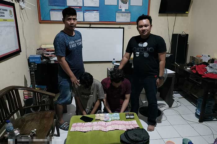 Kedua pelaku uang palsu saat diamankan di Polsek Paninggaran, Sabtu (22/7).&nbsp;