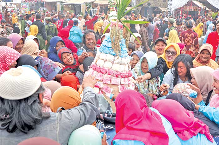 Warga berebut gunungan apem setelah didoakan. Grebek Apem sendiri baru kali pertama ini digelar di Desa Mojosari.