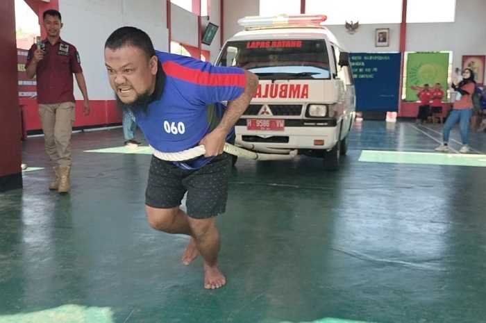 Seorang napi sedang berusaha menarik ambulans&nbsp;untuk menguji ketahanan fisik serta memeriahkan Hari Kemenkumham ke-78.&nbsp;&nbsp;