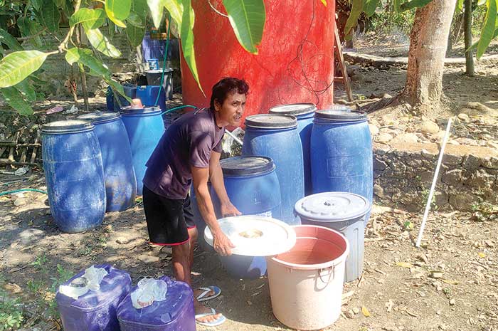 Mujiono saat menunjukkan beberapa jeriken milik warga yang masih ditinggal di sekitar tandon.