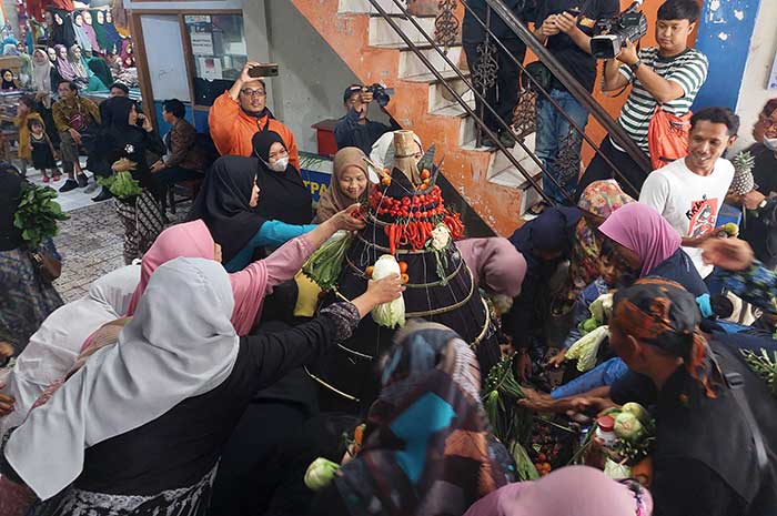 Pedagang dan pengunjung pasar memperebutkan gunungan hasil bumi di akhir acara wilujengan di Pasar Tradisional Kliwon Temanggung, Kamis (3/8).