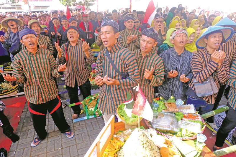KHUSYUK : Masyarakat Kecamatan Bulu melakukan doa bersama dalam acara merti bumi dan wiwit panen mbako, Jumat (4/8) pagi. (ADDIN ALFATH/ JAWA POS RADAR MAGELANG)