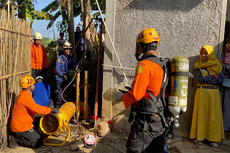 EVAKUASI: Tim Operasi SAR gabungan dengan cepat mengeluarkan Mustofa dan Romli, warga Jetis RT 01/RW 02 yang terjebak di dalam sumur, Kamis sore (10/8).