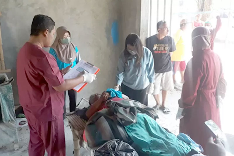 DIEVAKUASI: Petugas evakuasi jenasah penjual arum manis yang ditemukan tergeletak di teras potong rambut di lapangan waru Sabtu (12/8) lalu. (POLSEK UNTUK RADAR KUDUS)