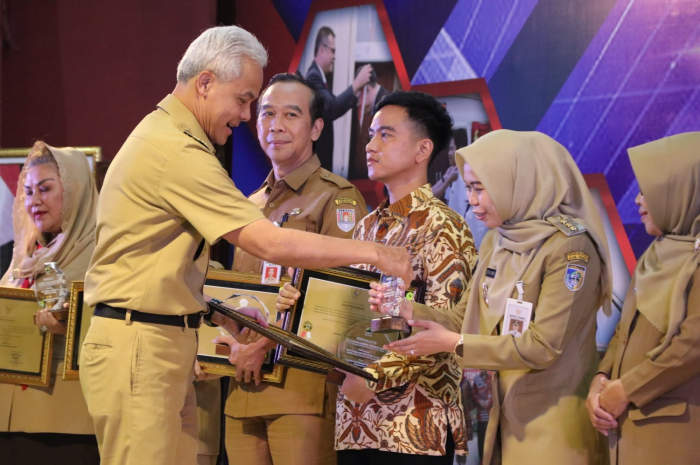 Gubernur Jateng Ganjar Pranowo menyerahkan penghargaan Bangkom Jateng Awards kepada Bupati Demak dr Hj Eistianah, SE.