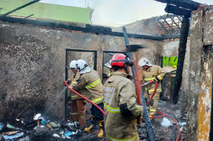 Petugas pemadam kebakaran Kota Semarang sedang menyiramkan air di sisa-sisa bara api yang telah meludeskan rumah Musrianto di Kedungpane, Mijen Kamis (17/8) pagi.