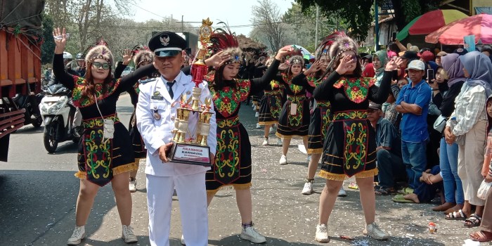 PAWAI KEMERDEKAAN : Kades Surodadi Muhlisin membawa piala bergilir di ajang karnaval tahunan Desa Surodadi, Kecamatan Gringsing, Kabupaten Batang, Minggu (20/3/2023).