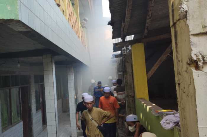 Puluhan santri Pondok Pesantren Darut Taqwa Semarang berusaha memadamkan api yang membakar ruang dapur, kemarin.