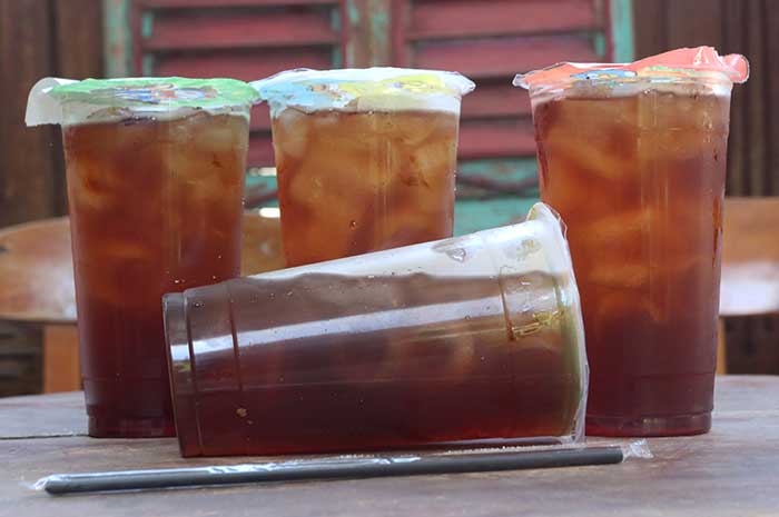 Minuman teh dalam kemasan gelas plastik.