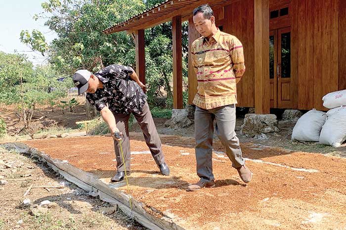 Kades Winong Angsori (kanan) saat menunjukkan jalan beton viral yang kini sudah diperbaiki sesuai spesifikasi Selasa (29/8).