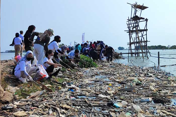 Sejumlah anak muda bergotong royong membersihkan sampah di pesisir Kampung Nelayan, Tambaklorok, Kota Semarang Sabtu (2/9).