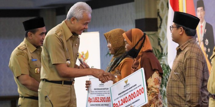 SERAHKAN BANTUAN : Gubernur Ganjar Pranowo dan Wagub Taj Yasin menyerahkan bantuan modal usaha ekonomi produktif, RTLH, dan jamban kepada ratusan keluarga miskin Jateng dari Baznas.
