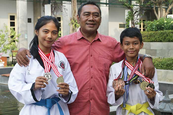 Dari Kiri Philia Gina Kazearea Maronta (kakak), Anggik Maronta (ayah), dan Graciano Laodikea Maronta menunjukkan medali kejuaraan TKD.
