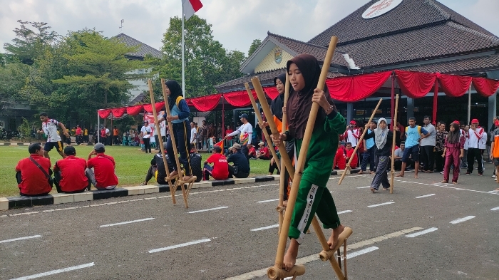 SERU: Para pelajar sedang berlomba adu cepat menggunakan egrang di halaman Pendopo Kabupaten Batang