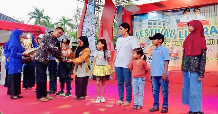 SERAHKAN - Kepala Dinarpus Kota Pekalongan, Soeroso saat menyerahkan hadiah lomba dalam penutupan Festival Literasi 2023 di Lapangan Mataram pada Minggu petang, (24/9).