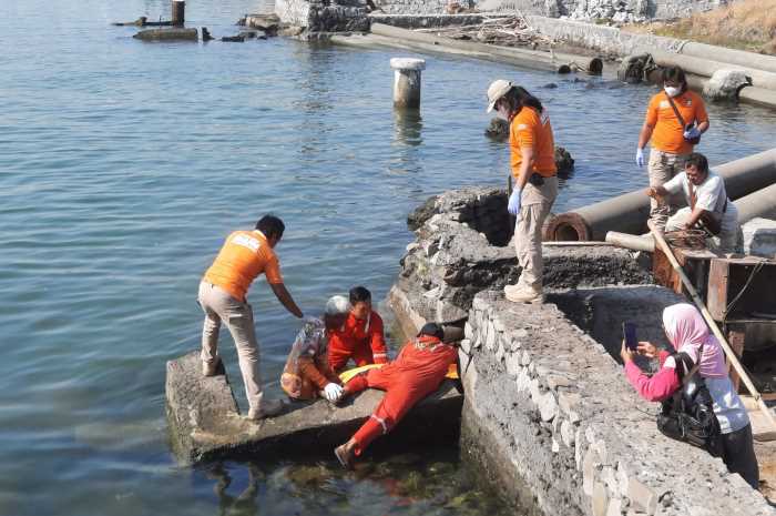 Petugas sedang mengevakuasi mayat yang ditemukan mengambang di gorong-gorong aliran air pintu air Janata Marina Indah 2 Rabu (27/9).