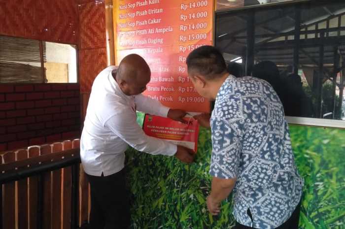 Petugas Gabungan Satpol PP dan BKUD Kabupaten Semarang saat memasang sticker dalam kegiatan operasi yustisi pajak di kawasan Bandungan dan Bawen.&nbsp;