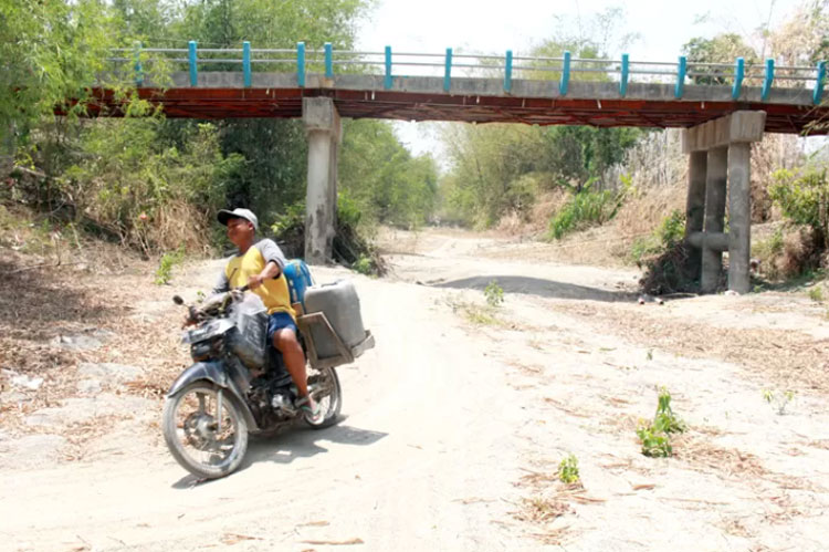 JADI JALAN: Warga Desa Asemrudung, Kecamatan Geyer melewati jalan dasar sungai mongering untuk berpergian ke sawah dan mengambil air sumber. (SIROJUL MUNIR/RADAR KUDUS)