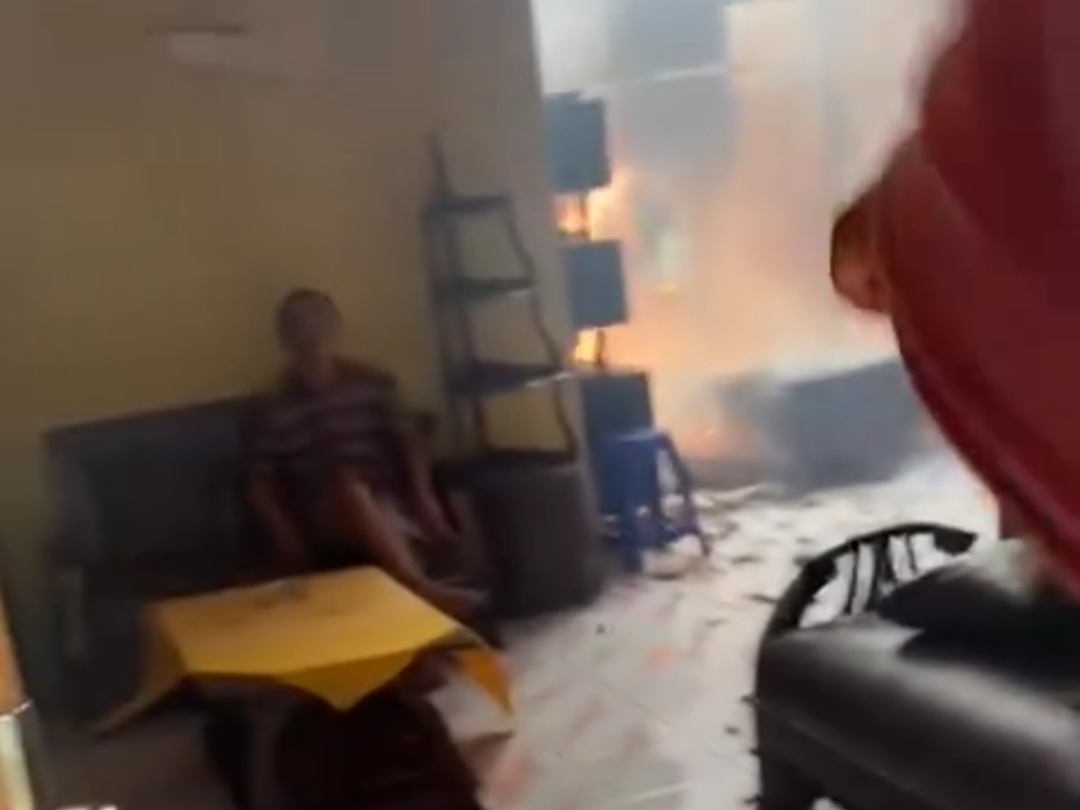 KEBAKARAN: Pemilik rumah terdiam di sofa saat api sudah membakar sebagian rumahnya. (istimewa)