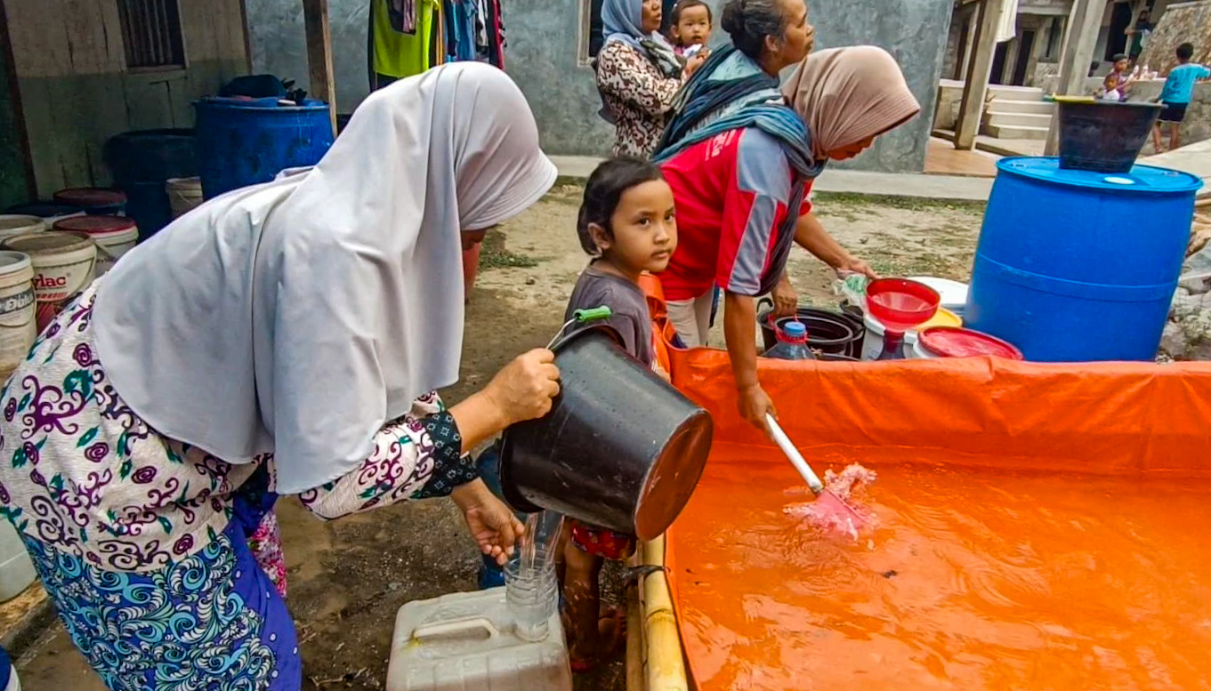 Warga Dusun Jagir saat mengambil air bersih yang disalurkan oleh para relawan