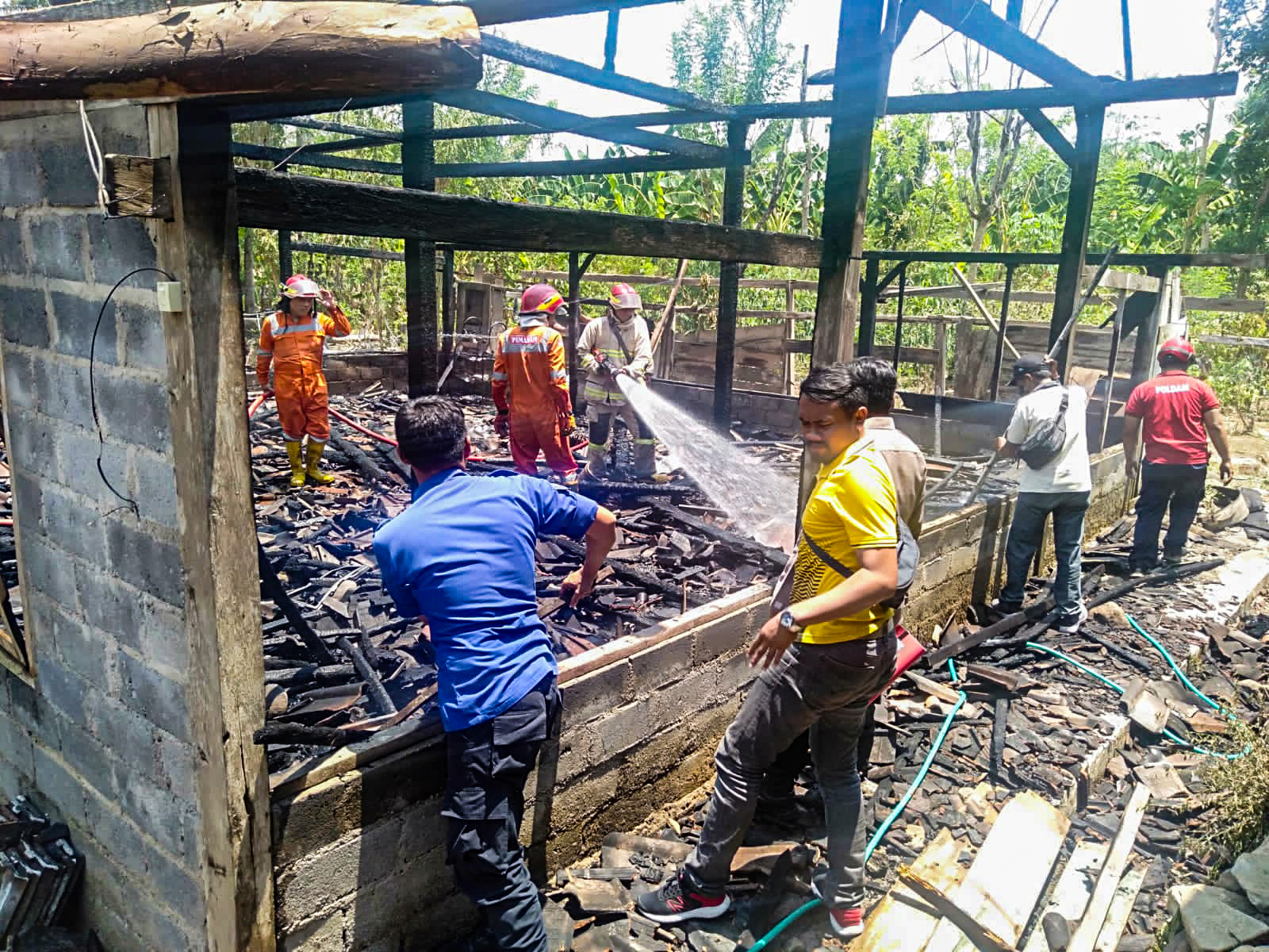 Petugas Damkar tengah melakukan pemadaman dan pendinginan api