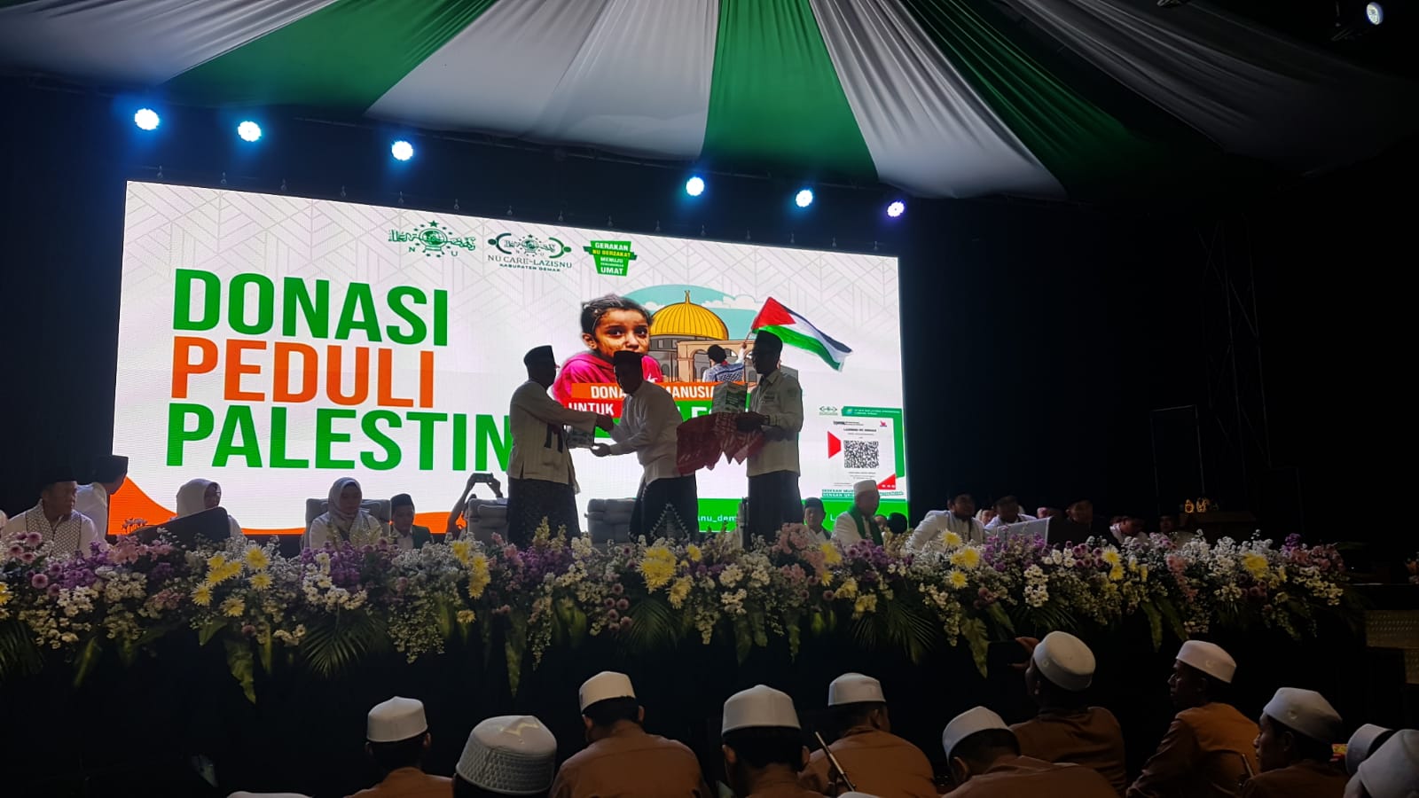Kepala Cabang PT BPR BKK Jateng KC Demak, Rusyadi Yogo Kusumo menyerahkan secara simbolis kotak amal dengan barcode Qris kepada Ketua PCNU Demak KH Aminudin. (Wahibpribadi)