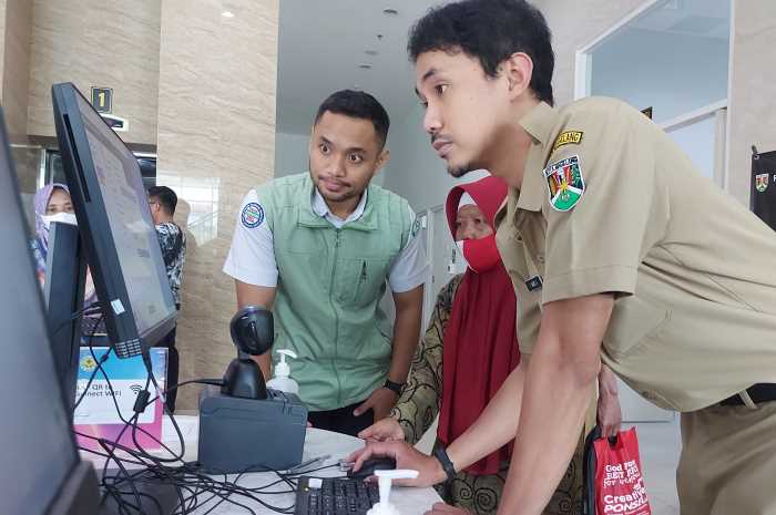 Petugas BPJS Satu Diko Adri Andi tengah membantu pasien RSUD Tidar Kota Magelang mendaftar pelayanan kesehatan menggunakan anjungan pendaftaran pasien.&nbsp; PUPUT PUSPITASARI/JAWA POS RADAR SEMARANG