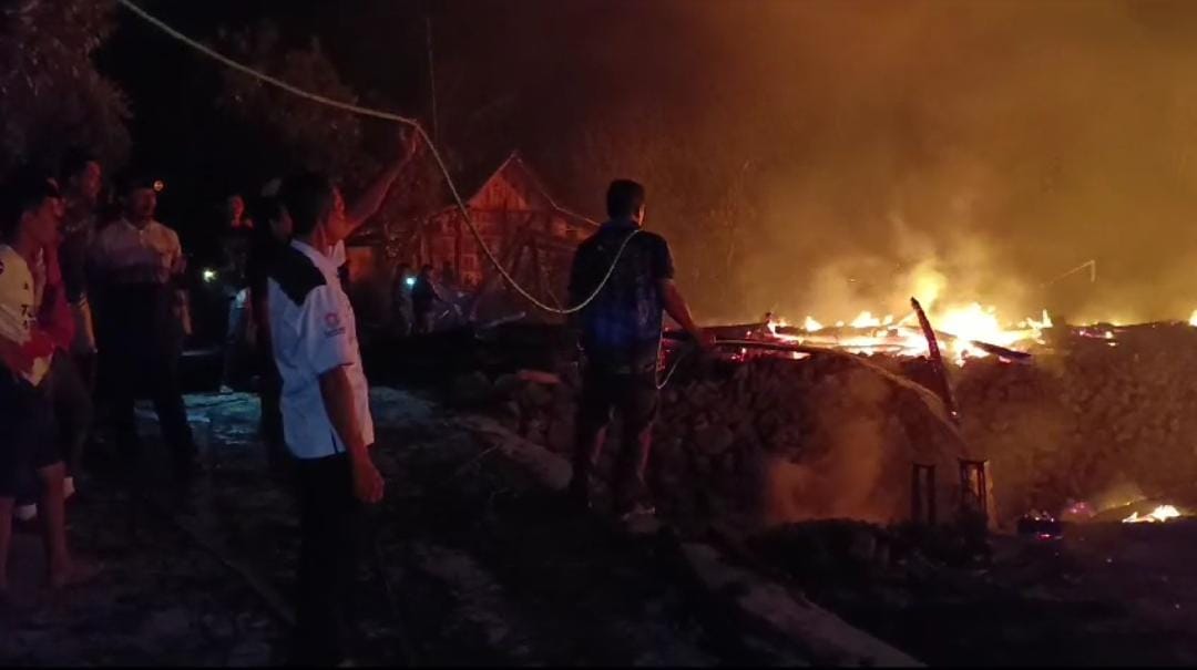 Warga tengah membantu petugas damkar dengan alat seadanya