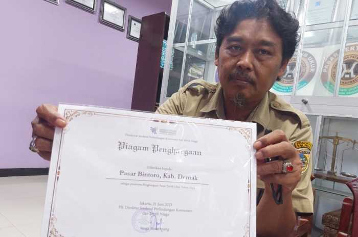 Plt Kepala UPTD Metrologi Legal, Edi Suprapto menunjukkan piagam penghargaan pasar tertib ukur dari Kementerian Perdagangan RI. (Wahib Pribadi/Jawa Pos Radar Semarang)