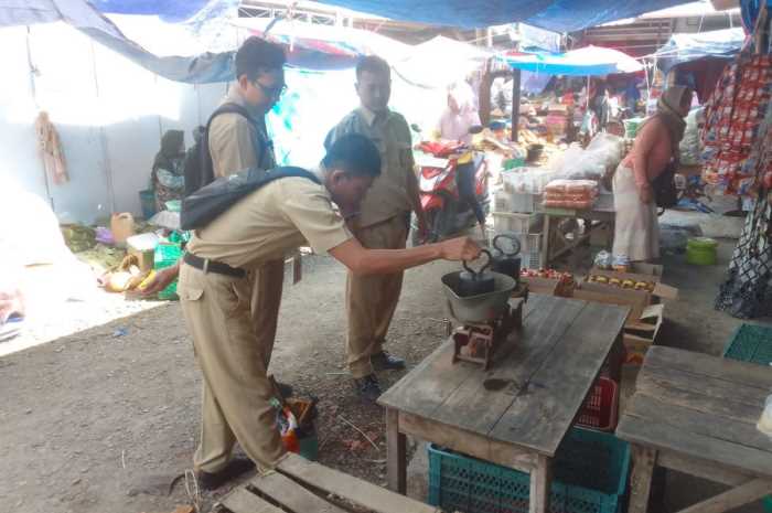 Petugas UPTD Metrologi Legal Dindagkop UKM Demak sedang menera ulang timbangan pedagang di pasar daerah. (Wahib&nbsp;Pribadi/JAWA POS RADAR SEMARANG)